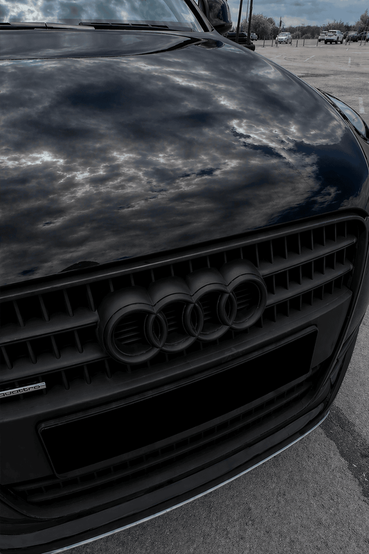 Close-up of an Audi car grille done with spray wrap with reflection on a cloudy day.